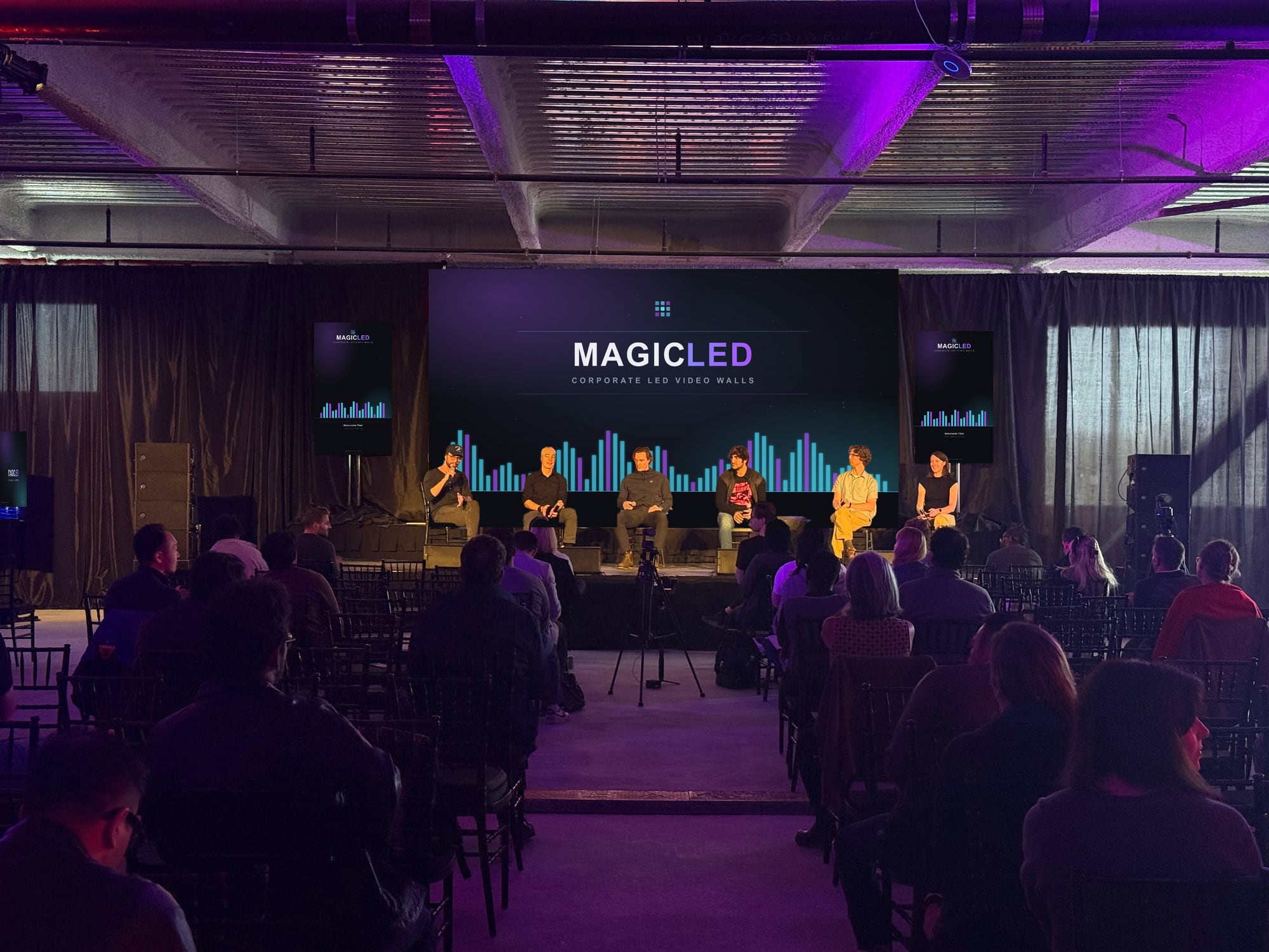 Audience facing a Magic LED wall and two portrait screens on stage