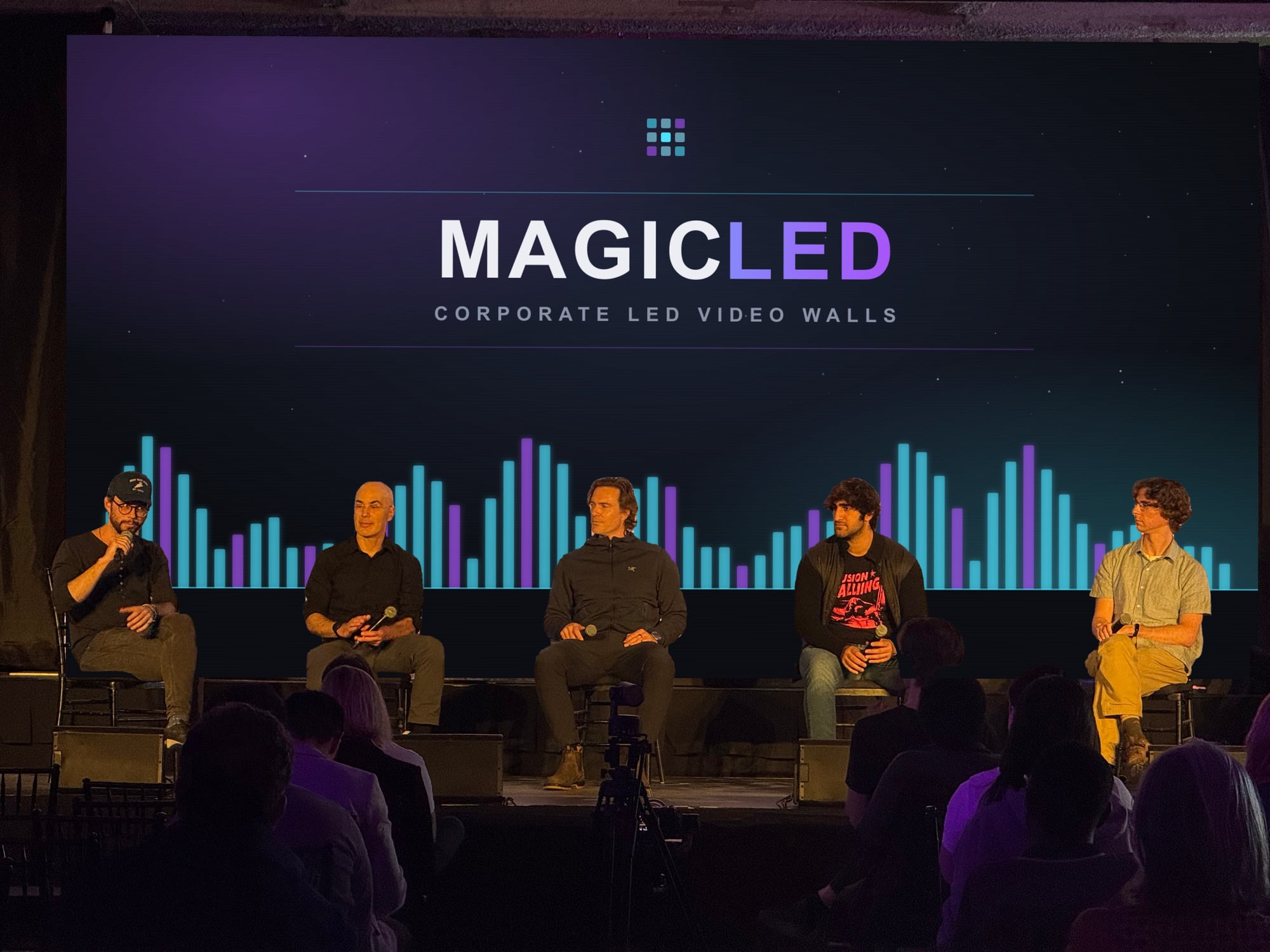 Close view of a five-person panel in front of a Magic LED wall