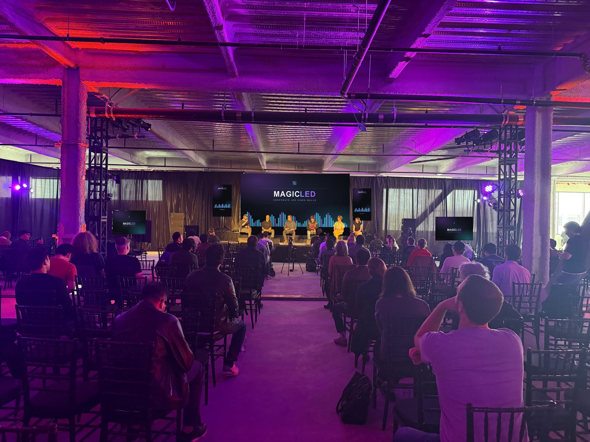 Center aisle view of a full room facing a Magic LED wall